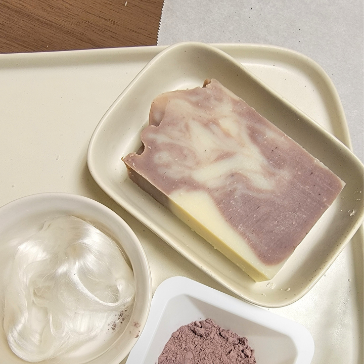 Indulge in the calming luxury of our Lavender Silk Natural Handmade Soap, crafted with skin-loving oils, butters, and botanical extracts for a gentle, hydrating cleanse. Infused with a serene blend of lavender, ylang ylang, and cedarwood essential oils, this soap soothes the senses while purple clay and alkanet root detoxify and refresh. Silk fibers create a rich, creamy lather, leaving skin soft, smooth, and deeply nourished.